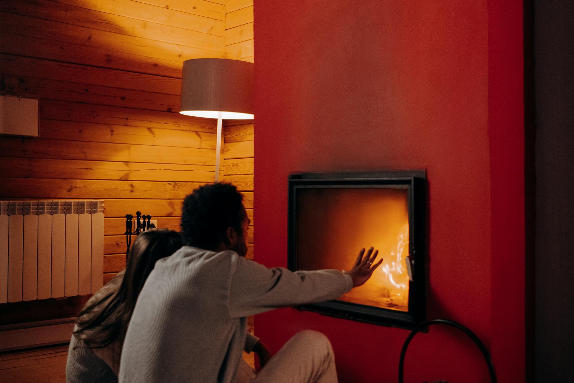 couple getting warm in front of furnace